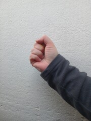 A man's clenched fist against a wall . Lots of space for text