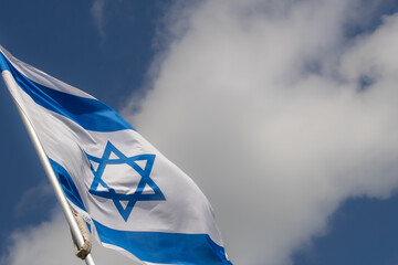 Large Israel flag waving in the wind. Israeli flag for advertising, holidays, achievements, festivals, elections. The Israeli flag flutters in the beautiful sky. Great for news.