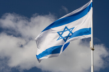 Large Israel flag waving in the wind. Israeli flag for advertising, holidays, achievements, festivals, elections. The Israeli flag flutters in the beautiful sky. Great for news.