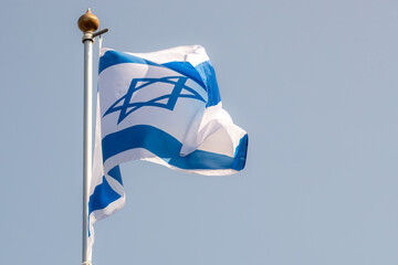 Large Israel flag waving in the wind. Israeli flag for advertising, holidays, achievements, festivals, elections. The Israeli flag flutters in the beautiful sky. Great for news.
