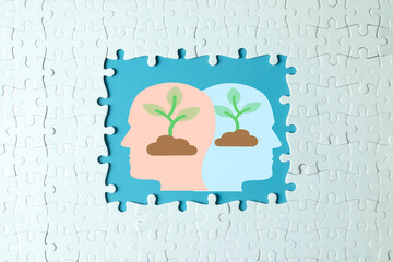 A puzzle reveals two heads with growing plants, symbolizing a growth mindset for developing new...