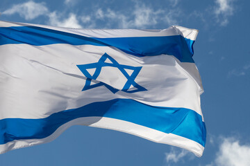 Large Israel flag waving in the wind. Israeli flag for advertising, holidays, achievements, festivals, elections. The Israeli flag flutters in the beautiful sky. Great for news.