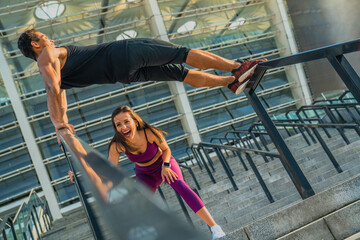 Cardio training sports young people. Healthy lifestyle. Stretching exercises running on the embankment in the city center. A couple in love shows a workout. Comfortable sportswear.