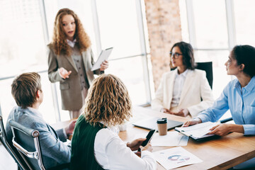 Business professionals collaborating during a meeting in a modern office environment, engaging in...