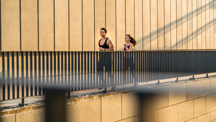 Couple, fitness and smile running in the city for exercise, workout or cardio routine together....