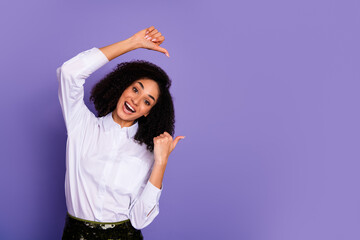 Happy young woman in a formal shirt posing with cheerful gestures against a vibrant purple...