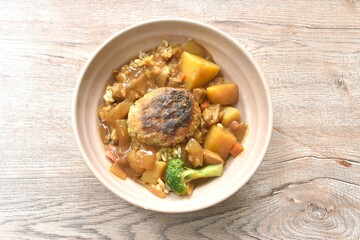 hamburg crispy fried chop pork with boiled vegetable topping plain rice dressing potato and carrot in Japanese curry on bowl