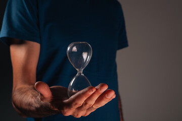 young man holding hourglass in his hands