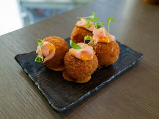 Delicious gourmet croquettes on black plate