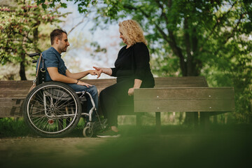 Inclusive connection demonstrated outdoors as two people engage in warm interaction on a bench,...