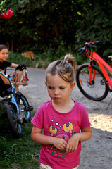 Children enjoying a sunny day while riding bikes and exploring the outdoors in a scenic neighborhood