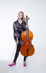 Woman in floral robe holding cello and bow.