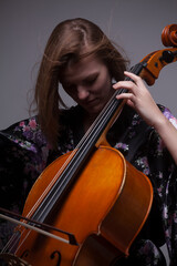 Woman playing cello, close-up, studio shot.
