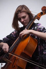 Woman playing cello, close-up, studio shot.