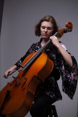 Woman playing cello in a floral kimono.