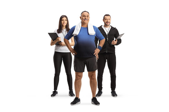 Fitness trainers posing with a mature male client