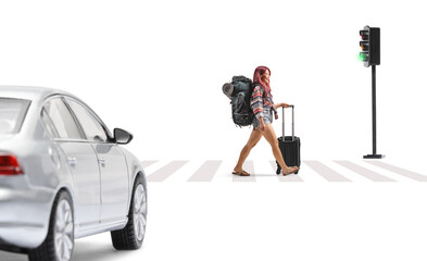 Female tourist with a suitcase and backpack walking at zebra crossing in front of a vehicle