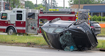 A crashed automobile had turned over and is laying on its side with the windshield smashed with a...