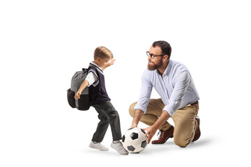 Man teaching schoolboy how to kick a football