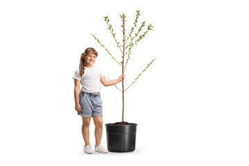 Girl holding the trunk of a young tree