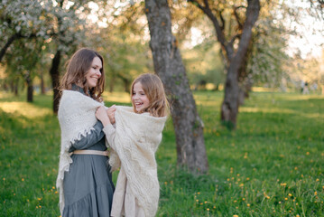 Mom and daughter play in the city park. They take care, cover each other with a handkerchief so as not to freeze. The concept of family, health, and care
