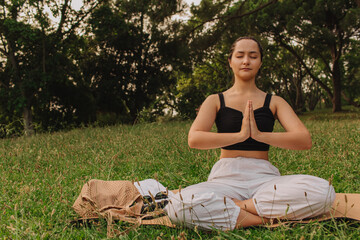 Fit sporty mindful young woman meditating, doing yoga and breathing exercises with eyes closed,...
