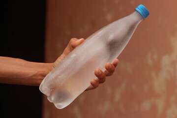 Hand holding a bottle of frozen water