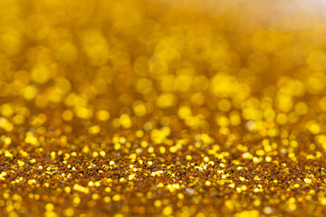 Golden glitter surface with shallow focus and bokeh lights in background. Perfect for festive...