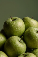 a lot of green ripe apples close-up with water drops