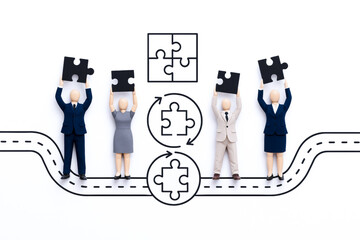 Business team working together to solve puzzle with concept diagrams and road map illustrations on white background, emphasizing agile leadership and teamwork skills in creative way