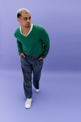 Young african american man showcases modern style against a vibrant purple backdrop