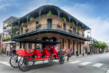 Sightseeing Horse Carriage tour and a typical building with balconies and columns in a street of the French Quarter, New Orleans, Louisiana