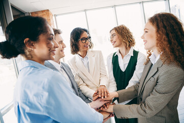Group of professional office coworkers engaged in teamwork and collaboration embracing teamwork...