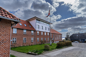 Red Brick Building with Flag on Cloudy Day Near Waterfront, Ronshoved, Denmark