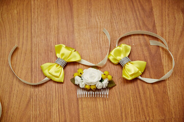 Three yellow bows are on a wooden surface