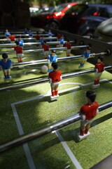 Exciting tabletop foosball game in action. Players compete by spinning rods to control miniature...