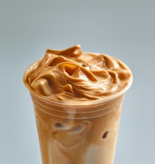 Close-up of caramel iced latte in a transparent cup showcasing swirling coffee texture blending with creamy milk, condensation droplets on the glass surface, commercial product photography