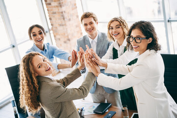 Professional team of young business colleagues collaborating in an office workspace, engaging in...