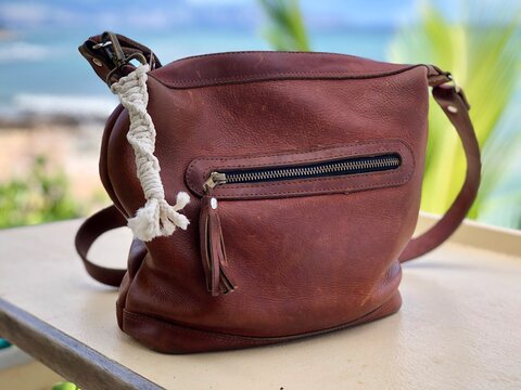 Leather purse with macrame pull with ocean in background