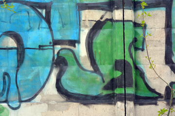 Unusual wall graffiti along the entire concrete fence in the form of unusual inscriptions of the Ukrainian style. They are painted with a can of blue, green and orange.