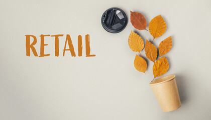 Leafy plant is in a paper cup and the word retail is written below it
