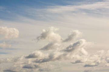Dramatic sky filled with layered cumulus and stratus clouds, showing movement and depth under soft...
