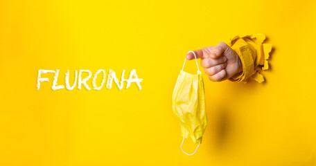 Person holding a yellow mask with the word Fluorna written in white
