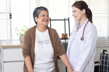Obraz premium Elderly, nurse, caregiver, patient, healthcare — A cheerful senior woman in a wheelchair chats with a young female doctor at a medical clinic, retired female, wellness, and trust in elderly care