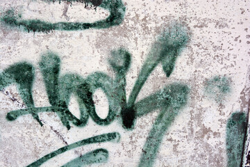 Drawings, graffiti, inscriptions on an old reinforced concrete fence, brick walls. Unusual text, signature in green with a smiley, a smile.