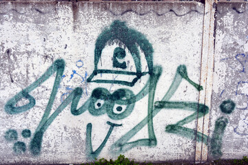 Drawings, graffiti, inscriptions on an old reinforced concrete fence, brick walls. Unusual text,...
