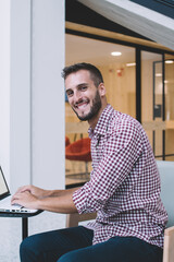 Satisfied successful freelancer using laptop at work space