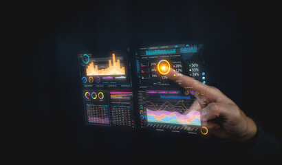 A hand interacts with futuristic transparent digital data charts displaying graphs, statistics, and analytics on a dark background.