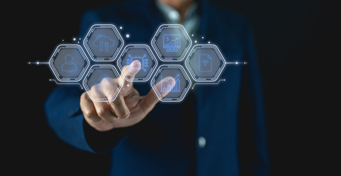 A person in a suit interacts with a futuristic digital interface displaying various business and financial icons.