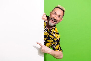 Charismatic middle aged man in floral shirt gesturing with enthusiasm against green background...